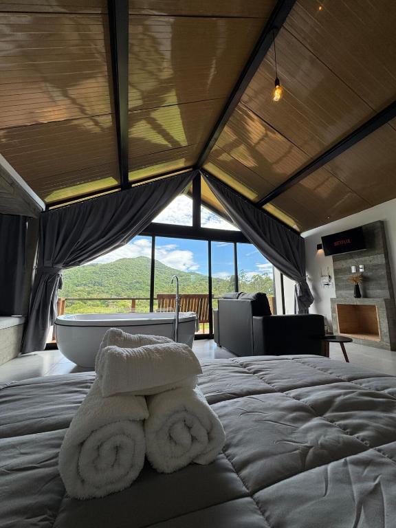 a bedroom with a tub and two towels on a bed at Hospedagem na natureza in Garopaba