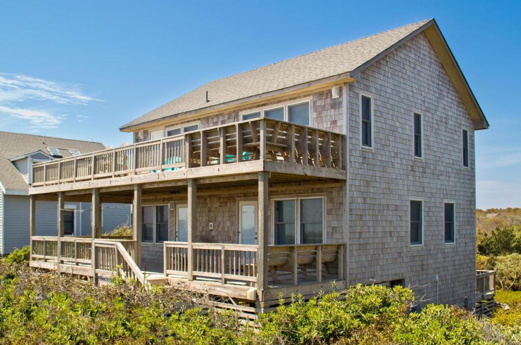 a large house with a deck on the beach at Breakaway - Duck, Sanderling, Oceanfront, Ocean View, Pets OK, Community Pool in Duck