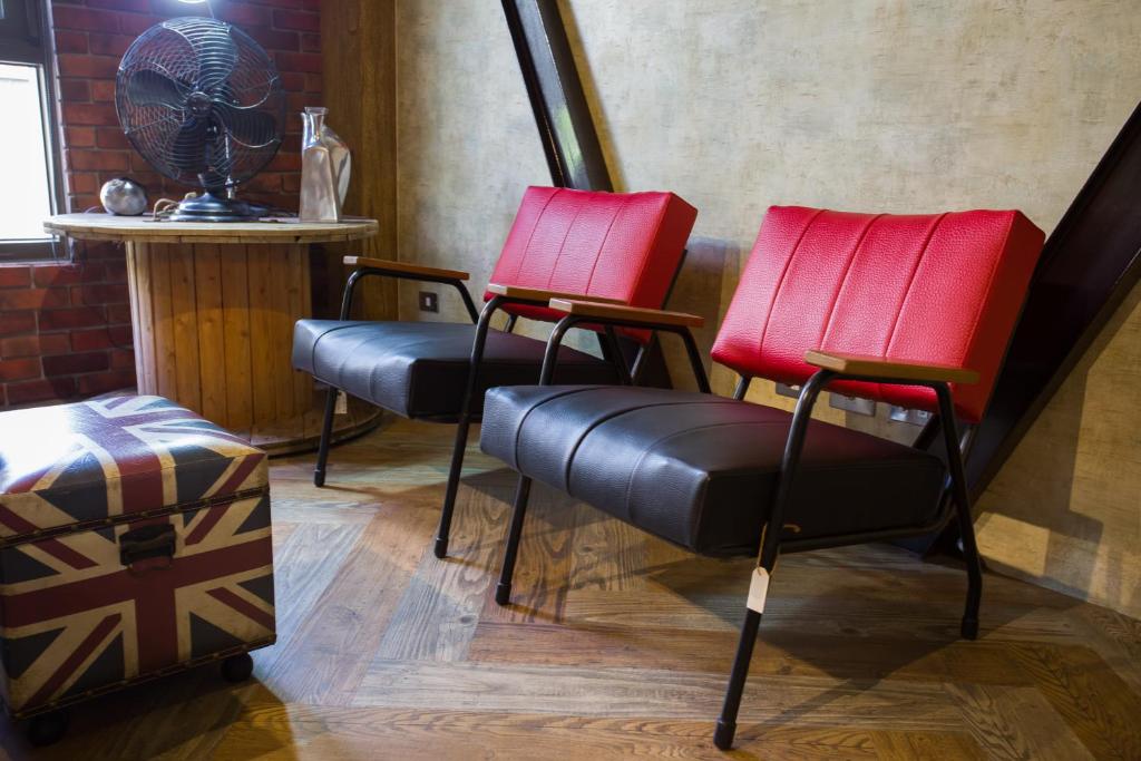 two red chairs and a fan in a room at Ji Ye Jing Zhan B&amp;B in Ji&#39;an
