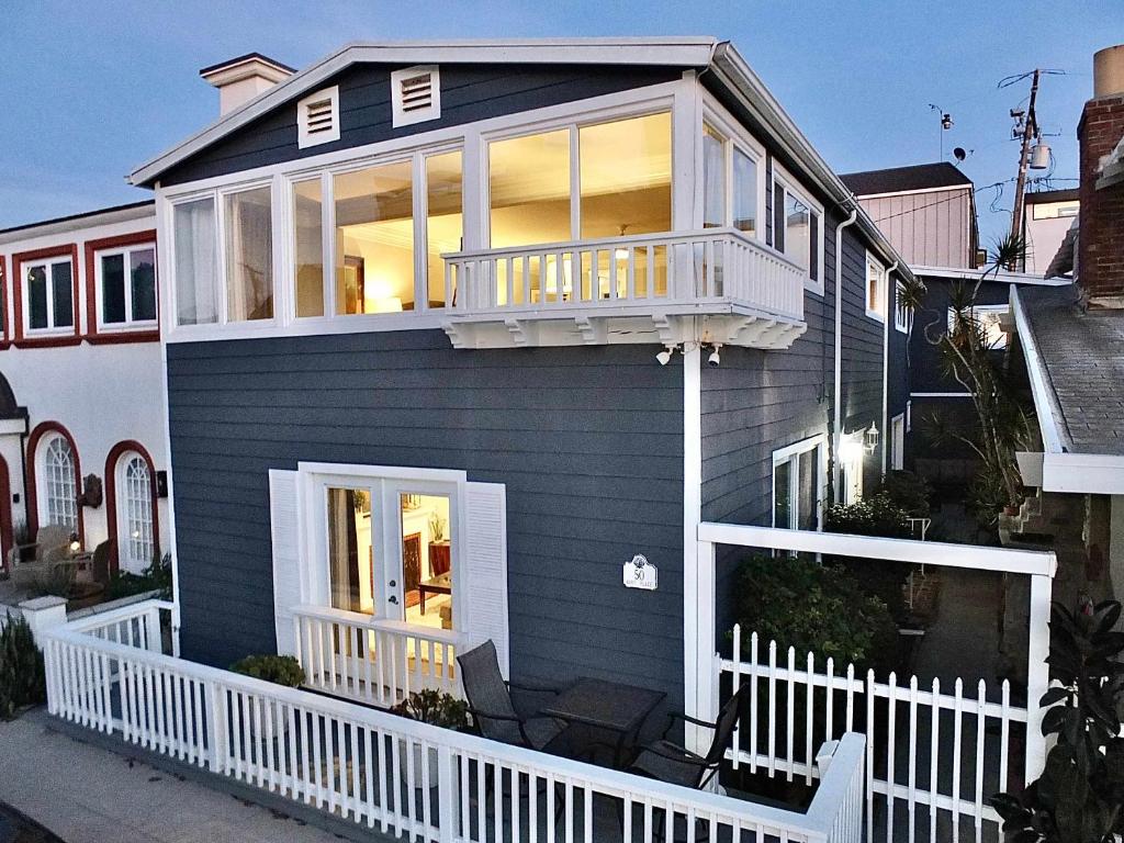 a blue house with a white fence and a balcony at LB Peninsula Steps to Beach close to in Long Beach