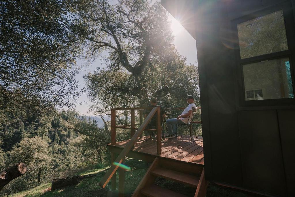 a couple of people sitting on a deck in a house at Off-Grid Tiny Home Pacific Views & Serenity in Pauma Valley