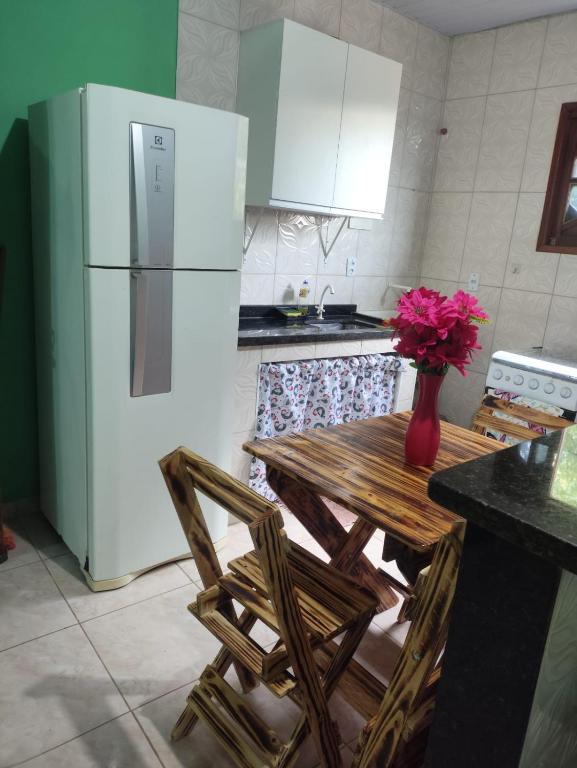 a kitchen with a table with chairs and a refrigerator at casa em Vila Verde Búzios in Búzios