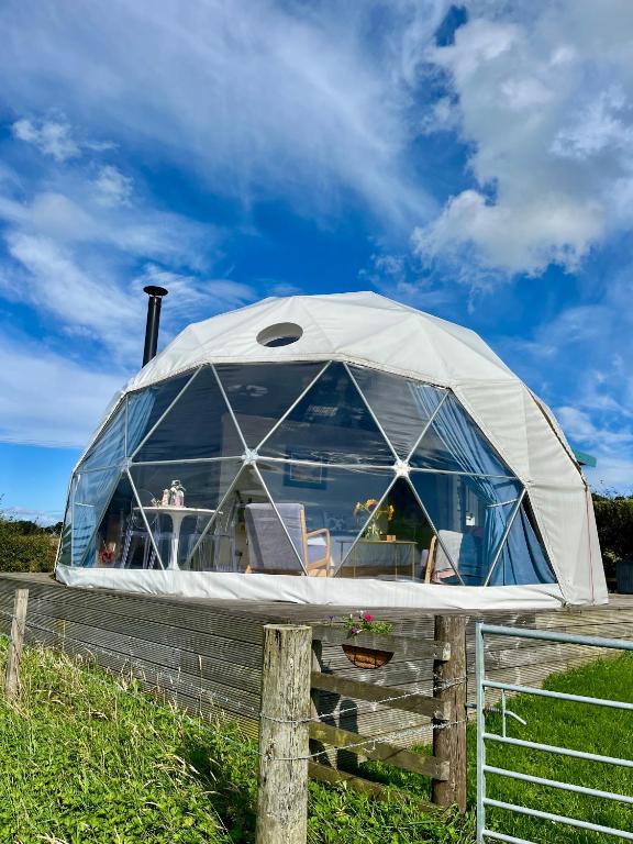 a dome tent on a fence in a field at The Dome at Midauchengowan in Lochwinnoch