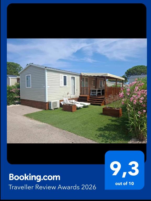 a tiny house in a yard next to a house at Bungalow Cinéric Nouveau 2026 in Canet-en-Roussillon