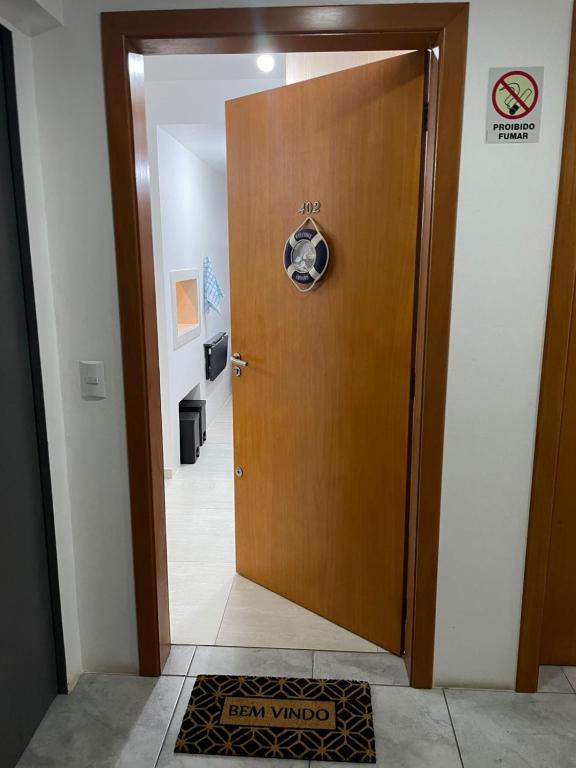 a wooden door in a hallway with a sign on it at Cantinho da Lyah in Torres