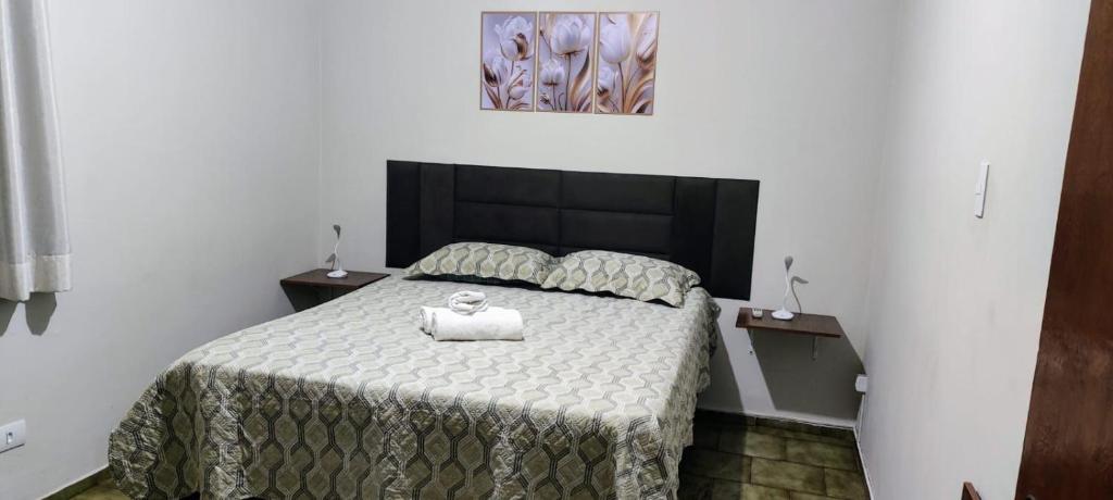 a bedroom with a bed with a towel on it at Habitaflex Casa No Centro de Urupês in Urupês