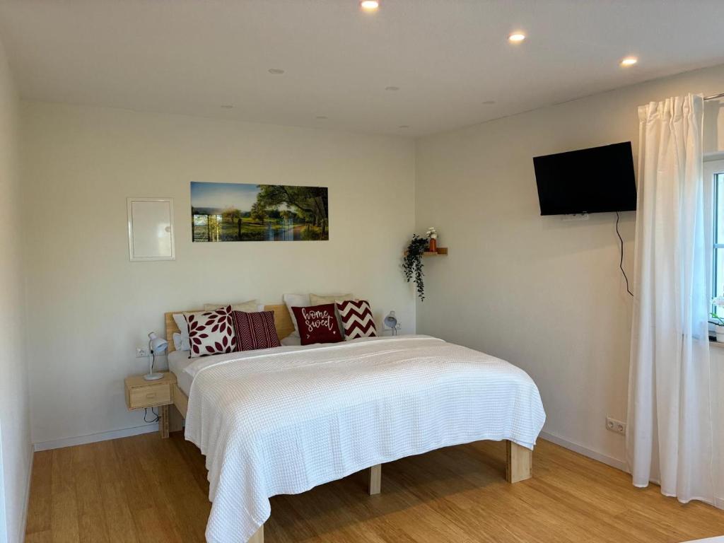 a bedroom with a bed and a tv on the wall at Ferienwohnung Weitblick Wiese in Neusitz