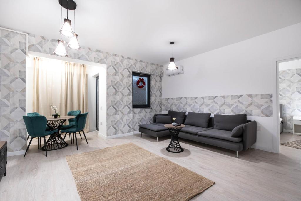 a living room with a couch and a table and chairs at Ivory Luxury 1BR in Voluntari