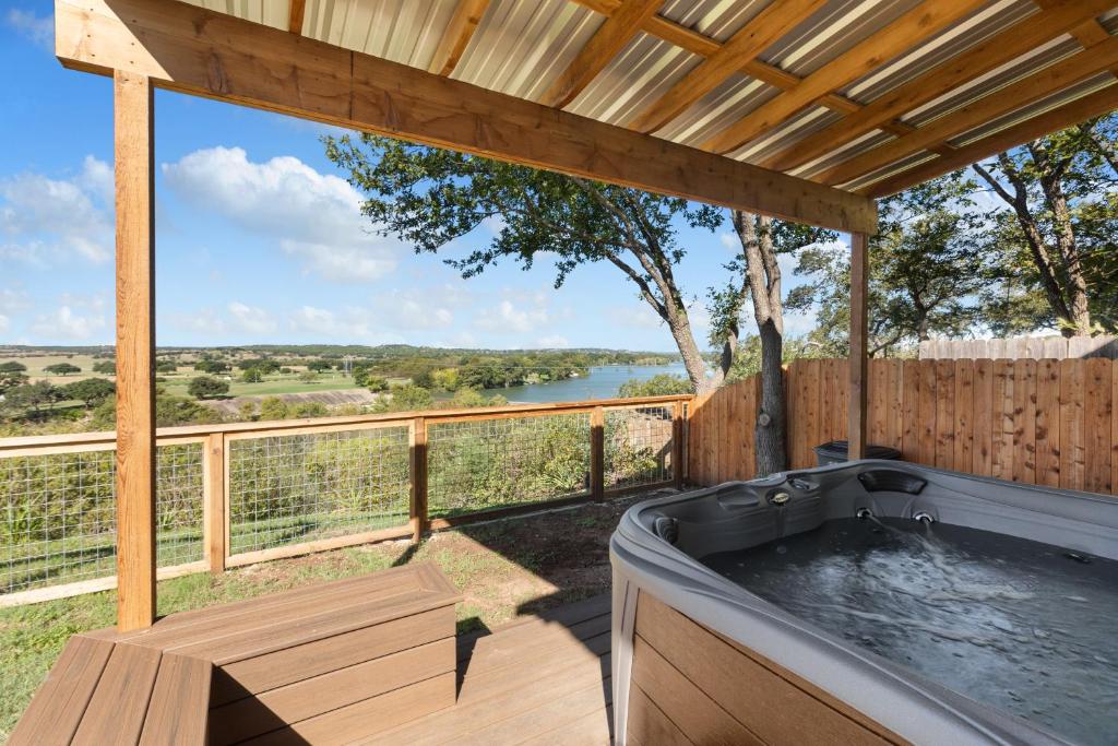 a hot tub on a deck with a view at Guadalupe Bluff Farmhouse in Kerrville