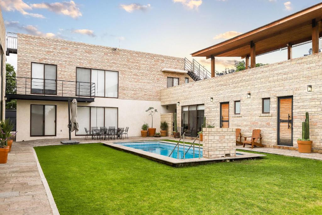 a brick house with a swimming pool in a yard at Bungalows in Samsara Atlixco in La Sabana