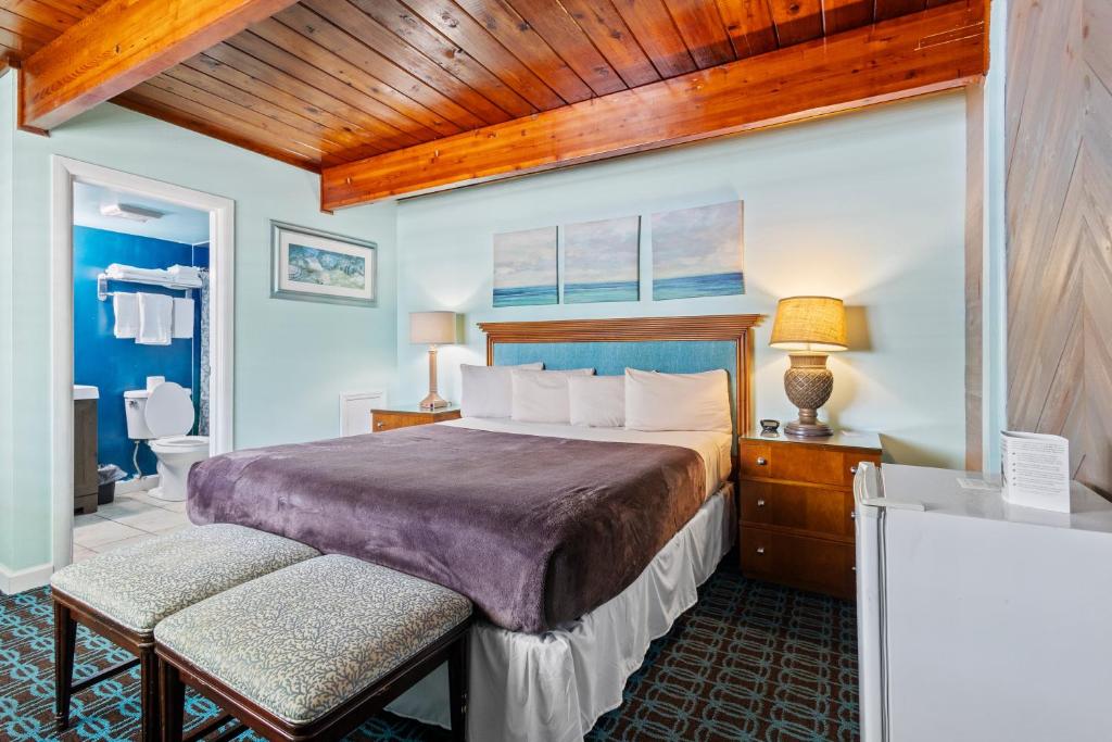 a bedroom with a large bed with a wooden ceiling at Oceanfront Inn Room #9 in Fort Pierce
