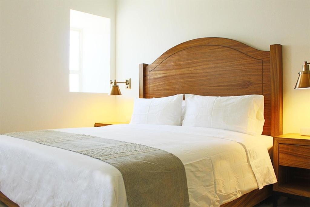 a bedroom with a large bed with a wooden headboard at Casa Maria Boutique Hotel in San Carlos