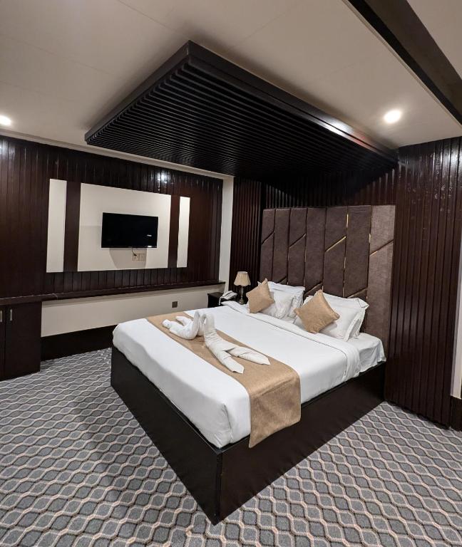 a bedroom with a large bed and a flat screen tv at Hotel Istanbul Sylhet in Sylhet