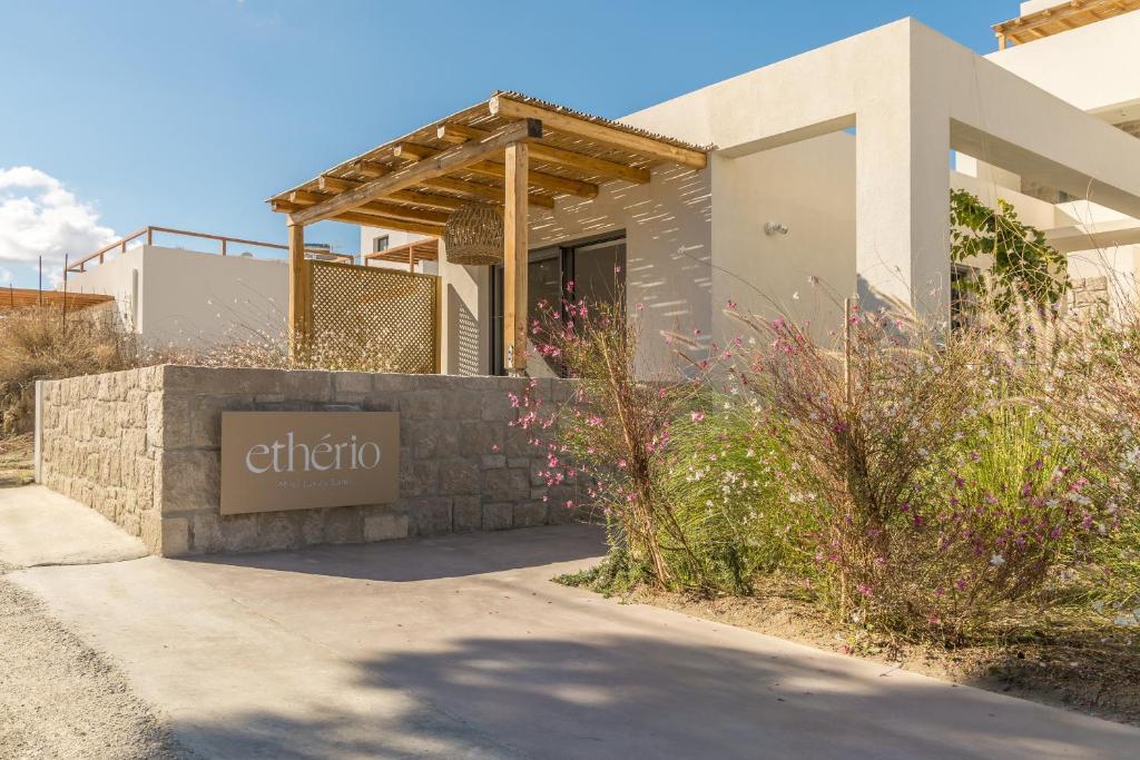 a house with a sign in front of it at Etherio Suites Milos in Pollonia