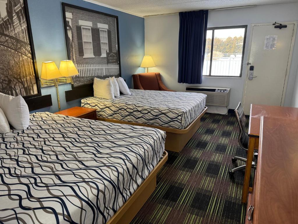 a hotel room with two beds and a window at Sprucewood Inn in Elyria
