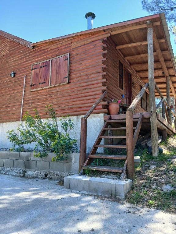 a wooden house with a staircase in front of it at Cabañas Soledad in Villa Giardino