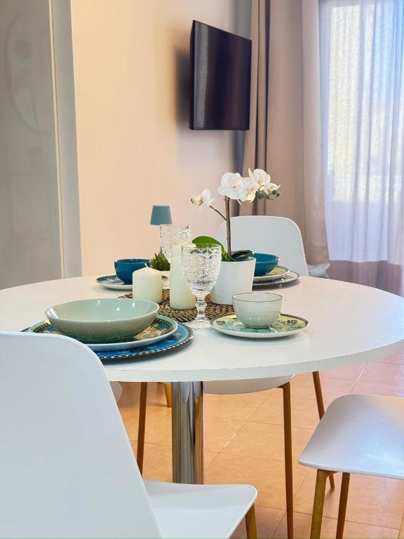 a white table with plates and bowls on it at NextGen Dimora Luna I Private Garden & Pool Fuerteventura in Costa de Antigua