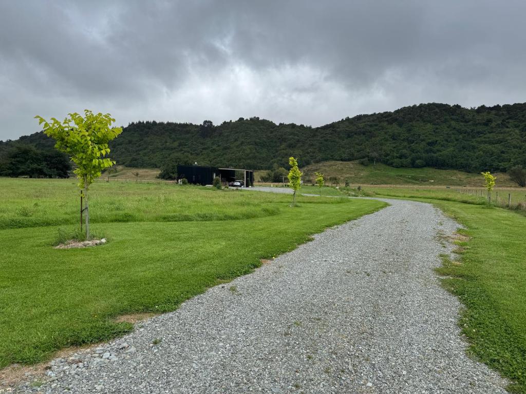 a gravel road leading to a building in a field at Bellbird Hideaway in Pleasant Valley