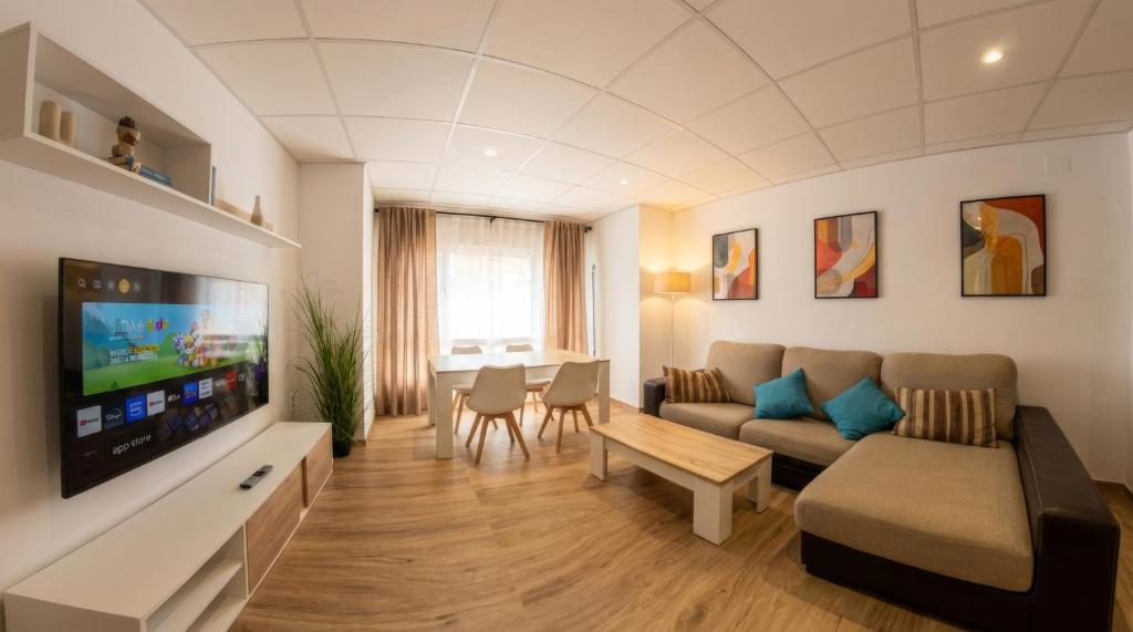 a living room with a couch and a tv at Apartamento moderno en el centro de Tavernes in Tavernes de Valldigna
