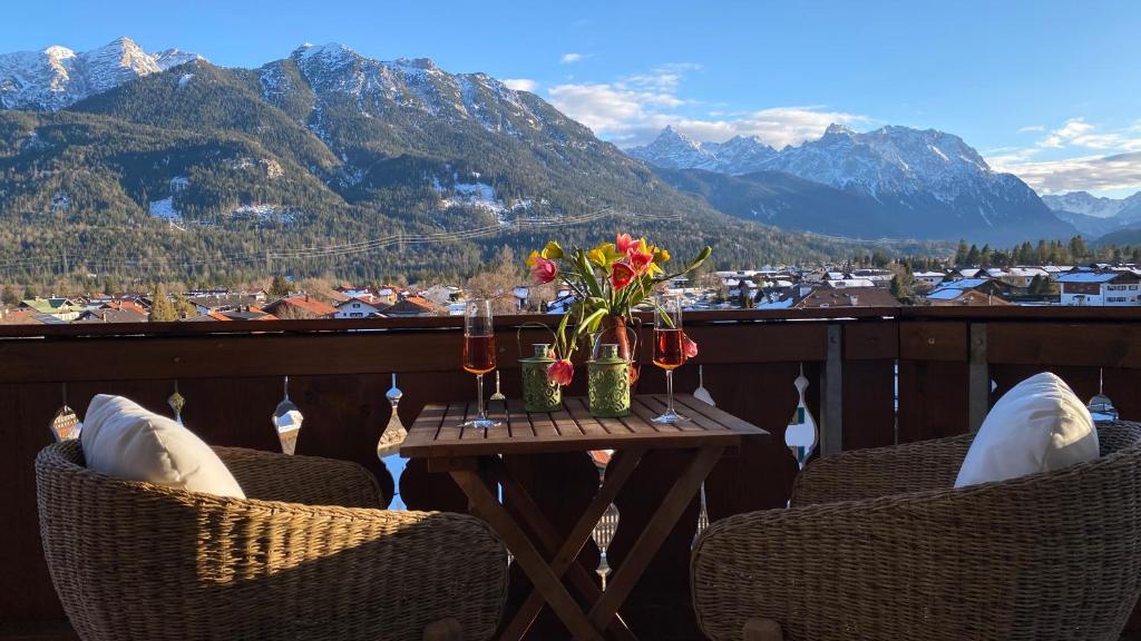 a table with flowers on a balcony with mountains at Apartment Sonnenhang in Wallgau