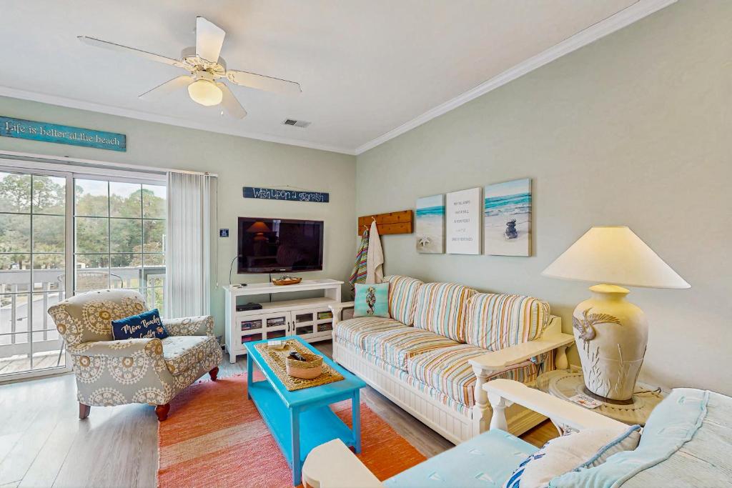 a living room with a couch and a tv at SB50 Saltwater Sanctuary in Sunset Beach