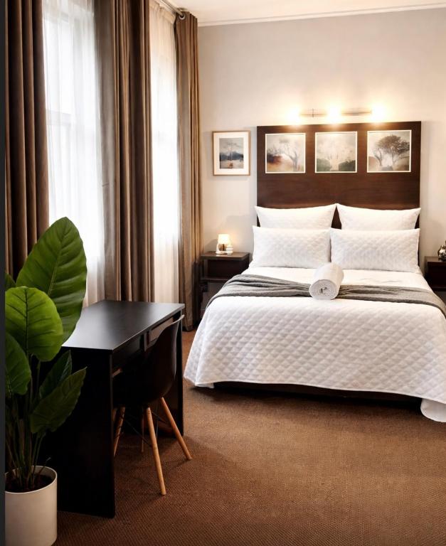 a hotel room with a bed and a desk and a plant at Mapungubwe Diamond's hotel in Johannesburg