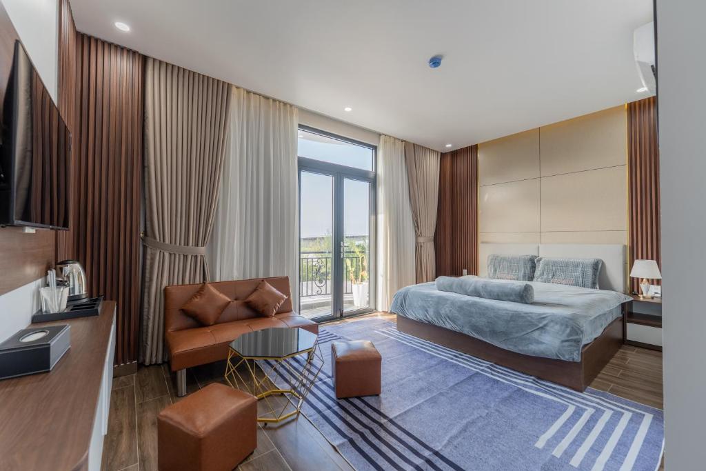 a bedroom with a king sized bed and a couch at Loc Binh Hotel in Thôn Phú An
