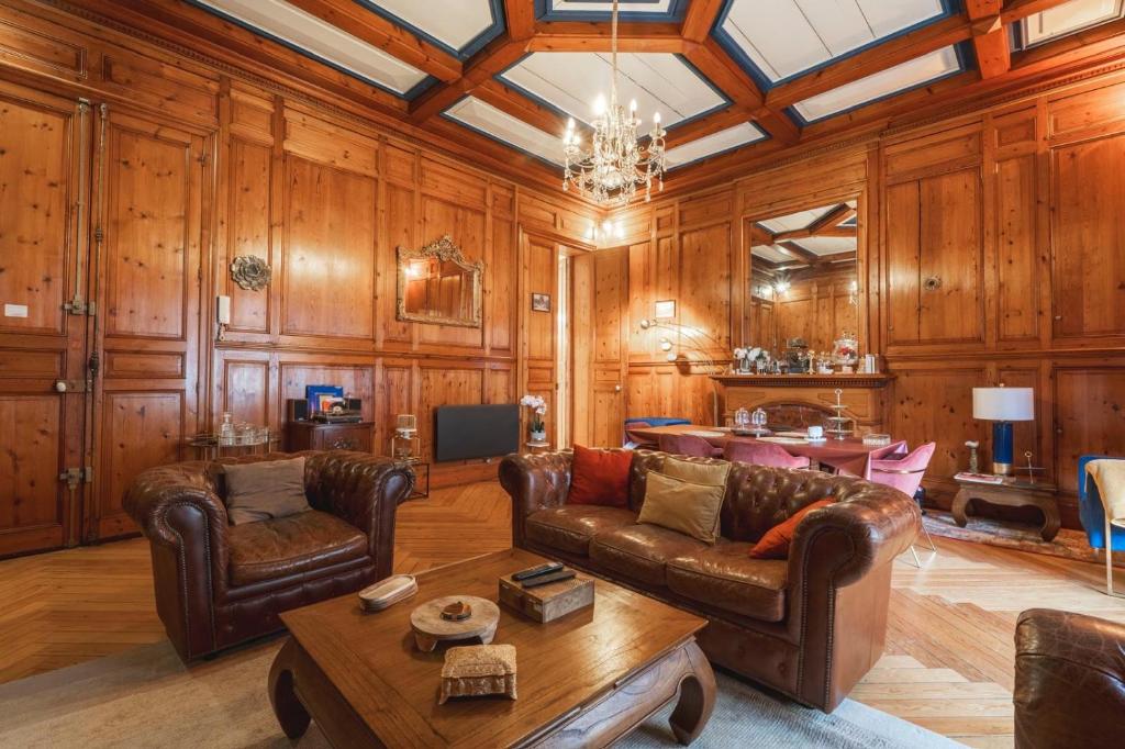 a living room with leather furniture and wooden walls at Prestige Étretat in Étretat