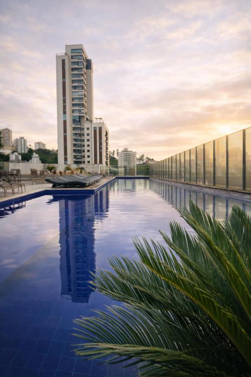 a swimming pool on the roof of a building with tall buildings at Ville Celestine Hotel in Belo Horizonte