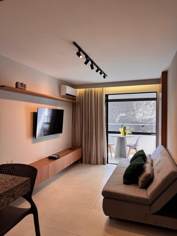 a living room with a couch and a flat screen tv at Apartamento novo aconchegante na Ondina in Salvador