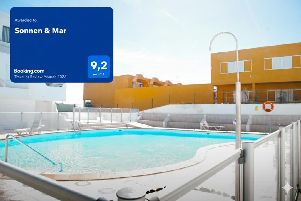 a swimming pool with a sign in front of a building at Sonnen & Mar in Antigua