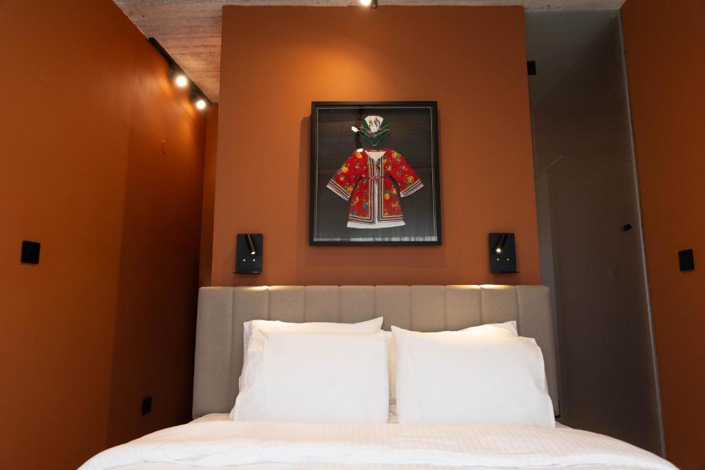 a bedroom with a bed and a picture of a dress on the wall at Echoes of Thrace in Xanthi