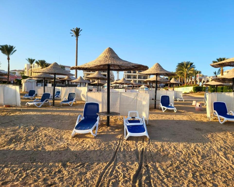 a group of chairs and umbrellas on a beach at Beachfront luxury Palm Beach Piazza Private Beach in Hurghada