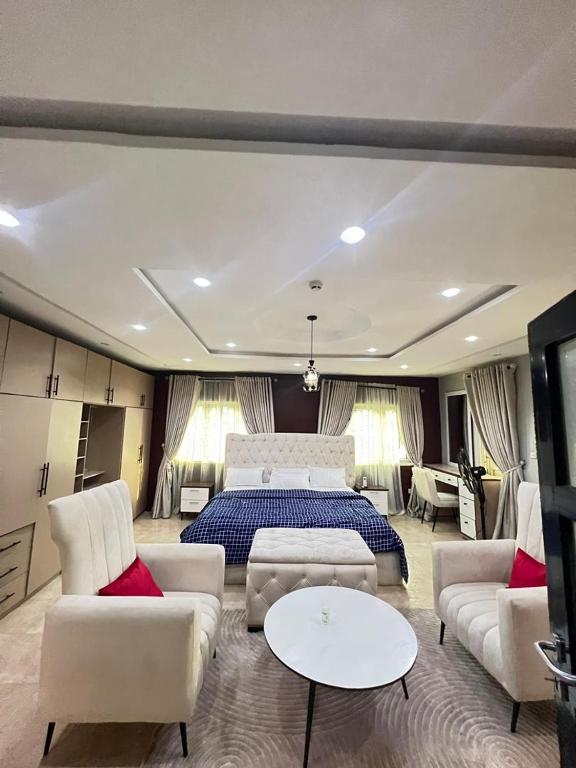 a large bedroom with a bed and white furniture at Shortlet247 in Hausa