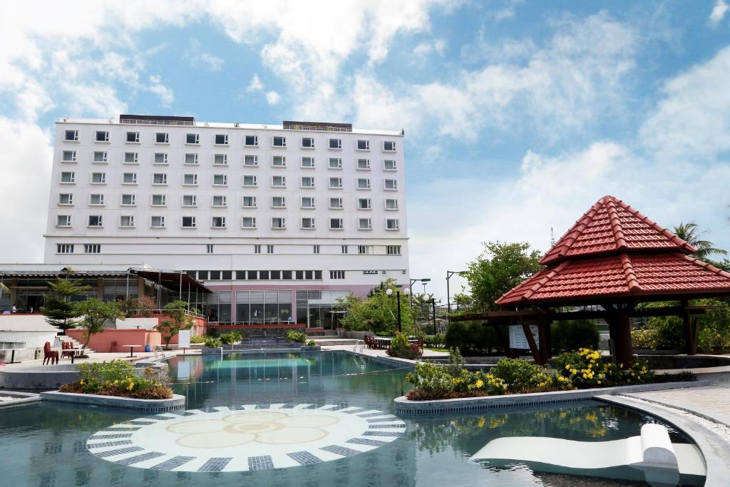 Quảng TrịにあるSai Gon Dong Ha Hotelの建物の前にプールがあるホテル