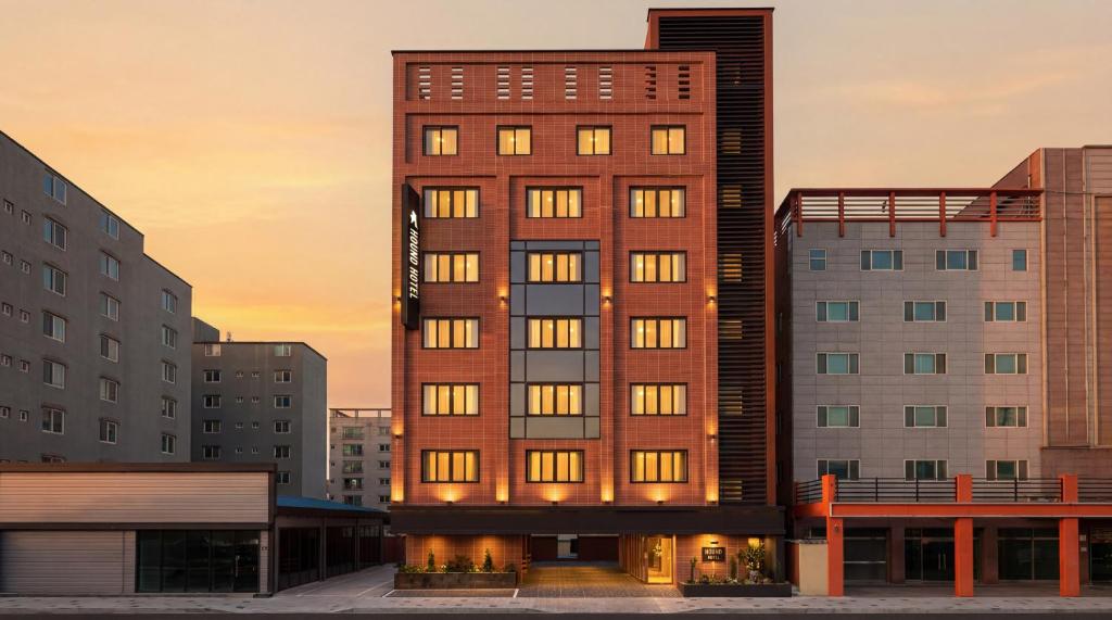 a tall brick building in a city with buildings at 통영 하운드호텔 죽림점 in Naejuk-to