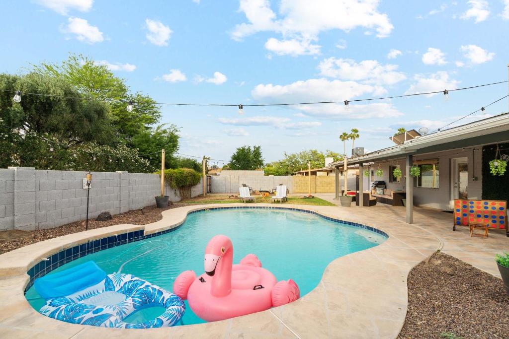 a swimming pool with a pink inflatable duck in it at Spacious Scottsdale Getaway with Pool in Tempe