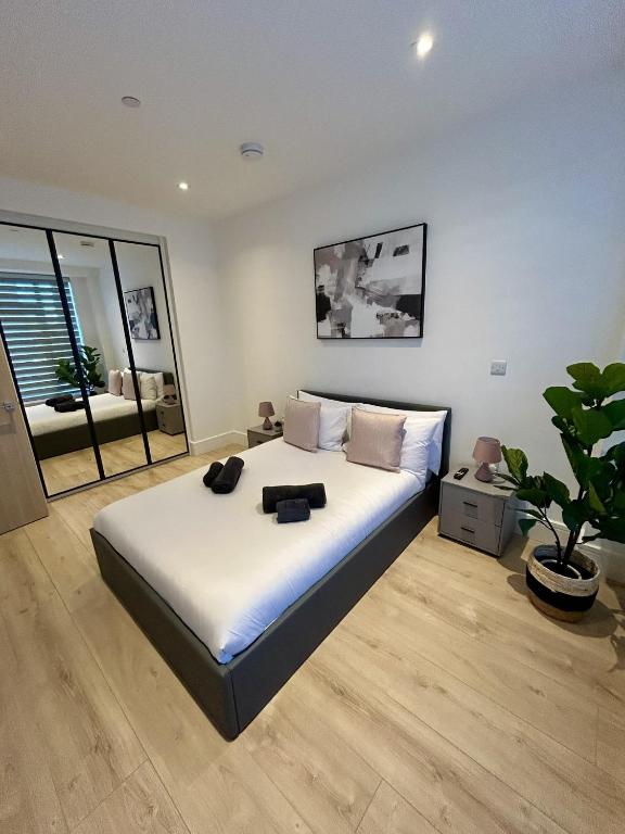 a bedroom with a large bed and a potted plant at 37 Syward Place in Chertsey