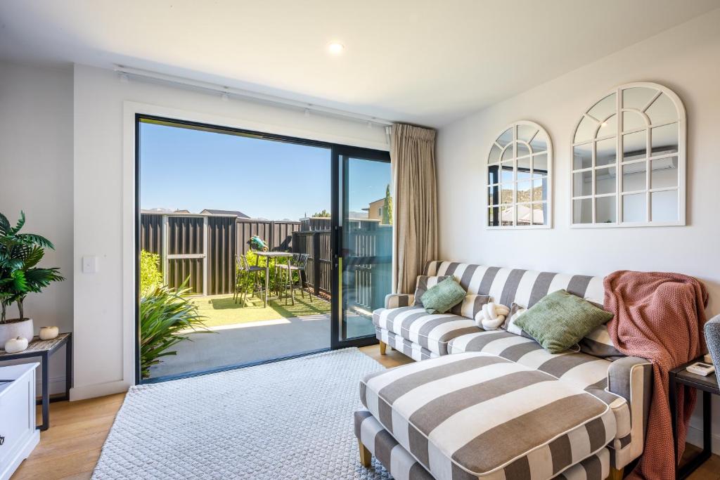 a living room with a couch and a sliding glass door at Flexible Bed Options, Private Back Yard, Car Park in Albert Town