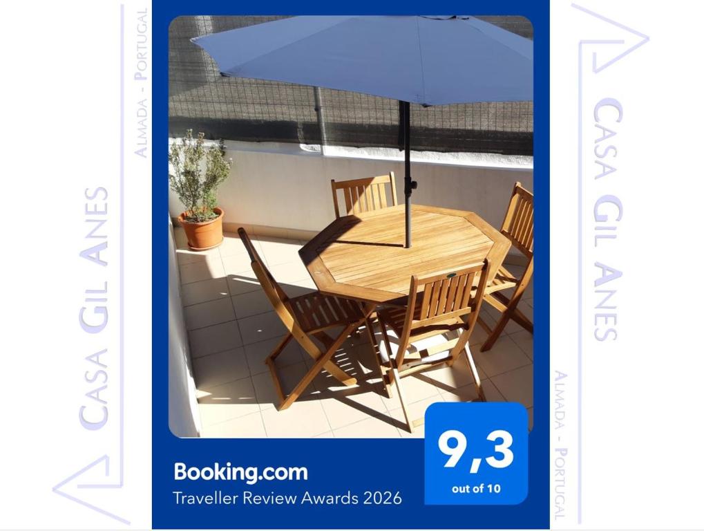 a picture of a table and chairs with an umbrella at Casa Gil Anes in Almada