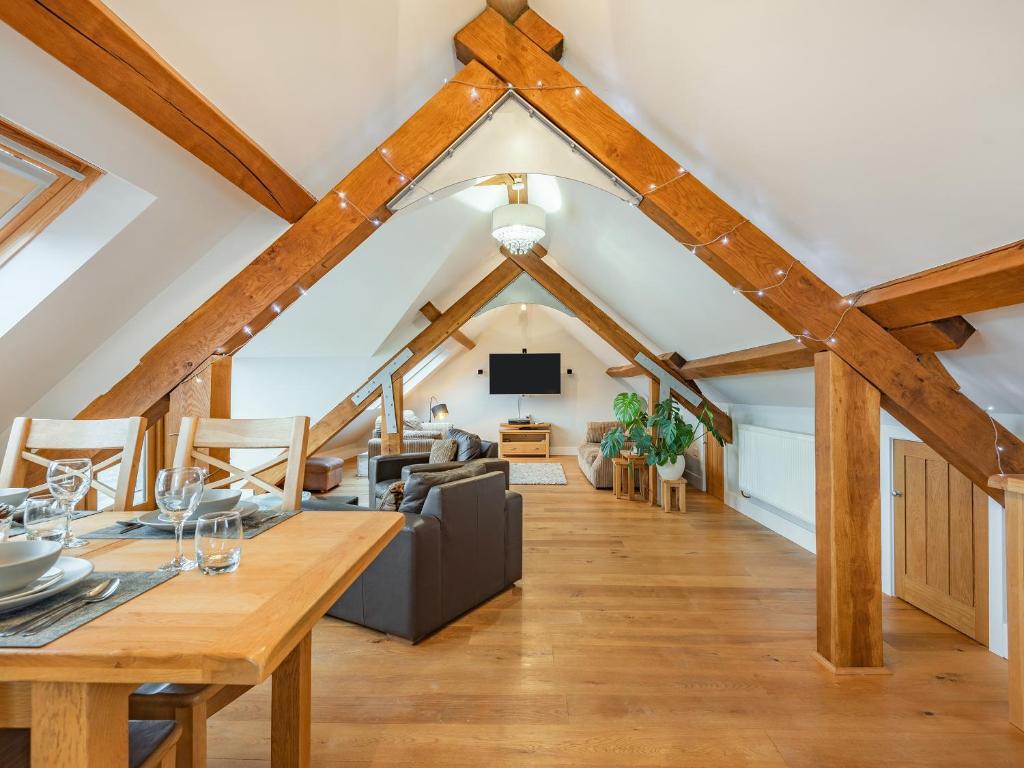 a living room with wooden ceilings and a dining room at The Barn At Whitefields in Walcot