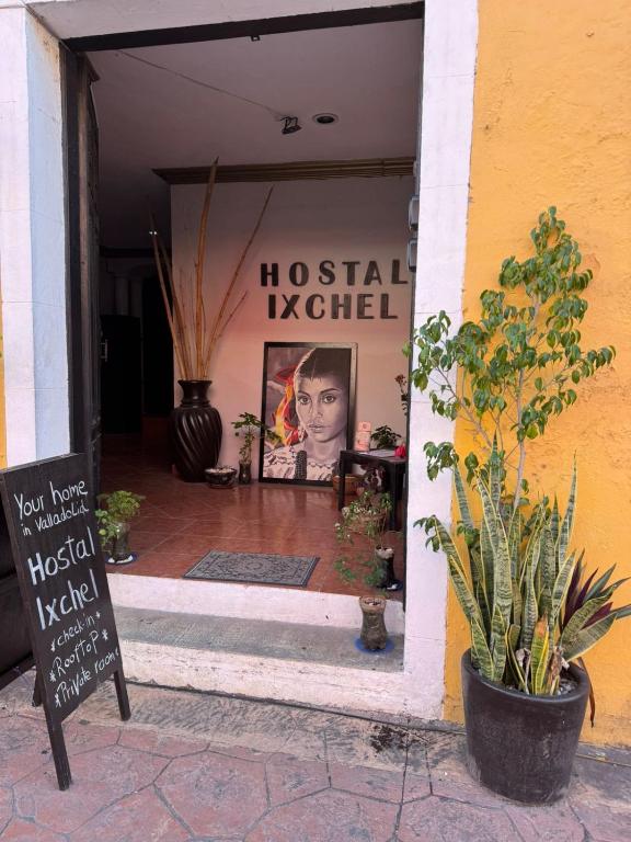 a store with a sign in the doorway of a building at Hostal Ixchel - AC, WiFi & Tours in Valladolid Downtown in Valladolid