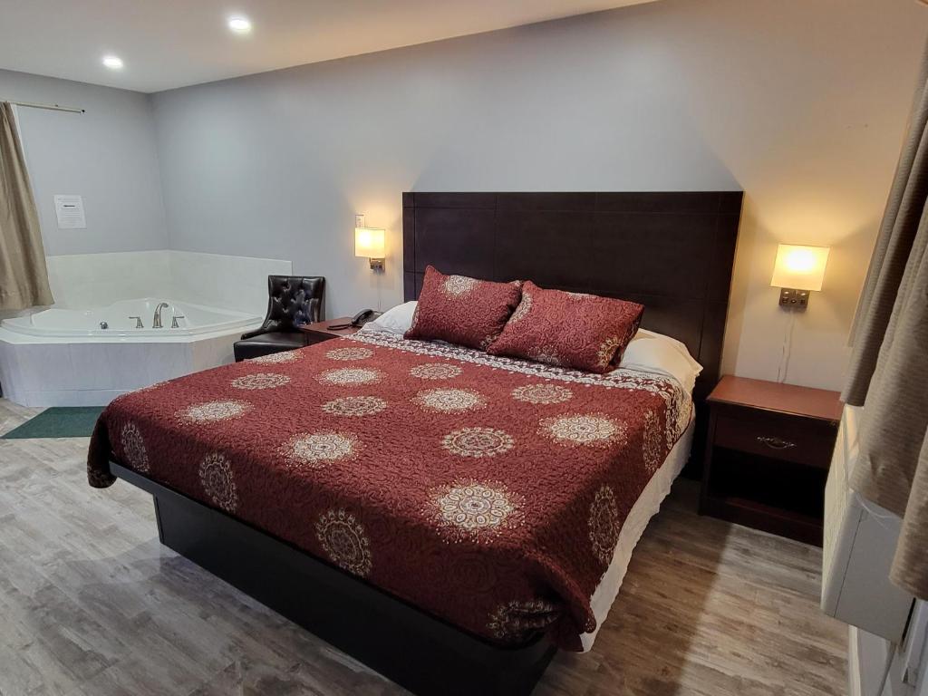 a bedroom with a bed and a bath tub at Cobourg Inn in Cobourg