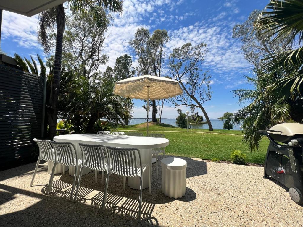 a white table with chairs and an umbrella at Villa Tarni Unit 7 in Mulwala