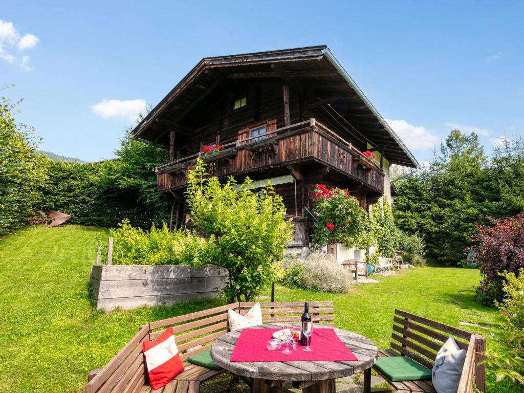 a wooden house with a picnic table in front of it at Weberhäusl am Penningberg in Hopfgarten im Brixental