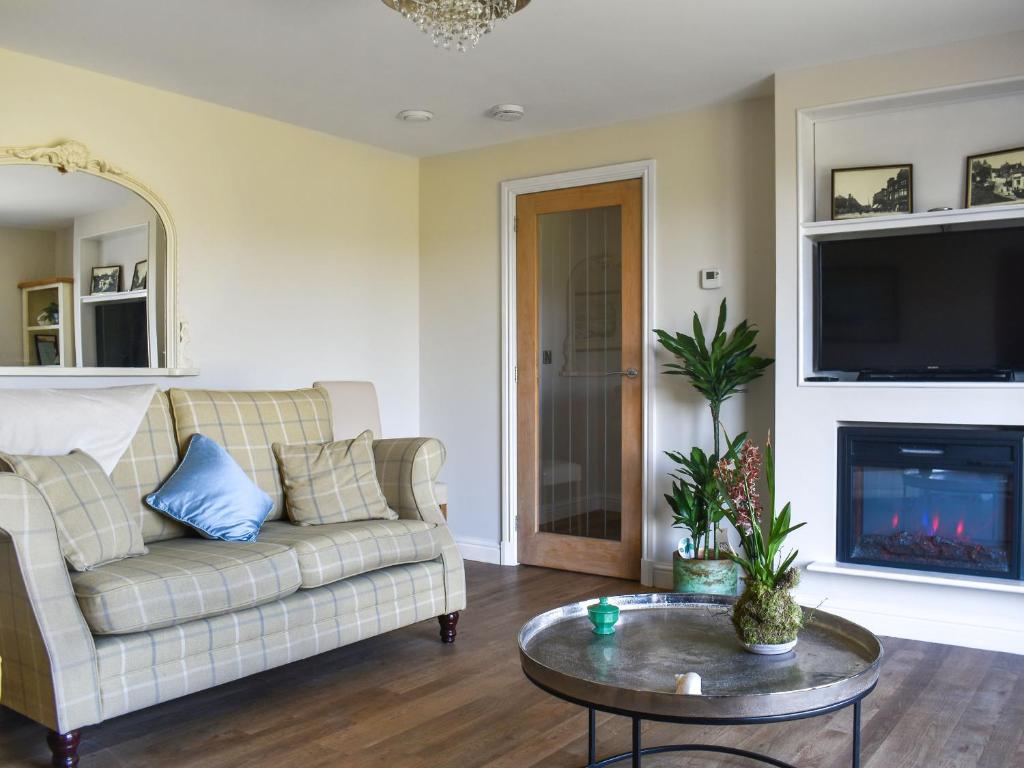 a living room with a couch and a fire place at The Wolfs Den - Uk49083 in Winewall