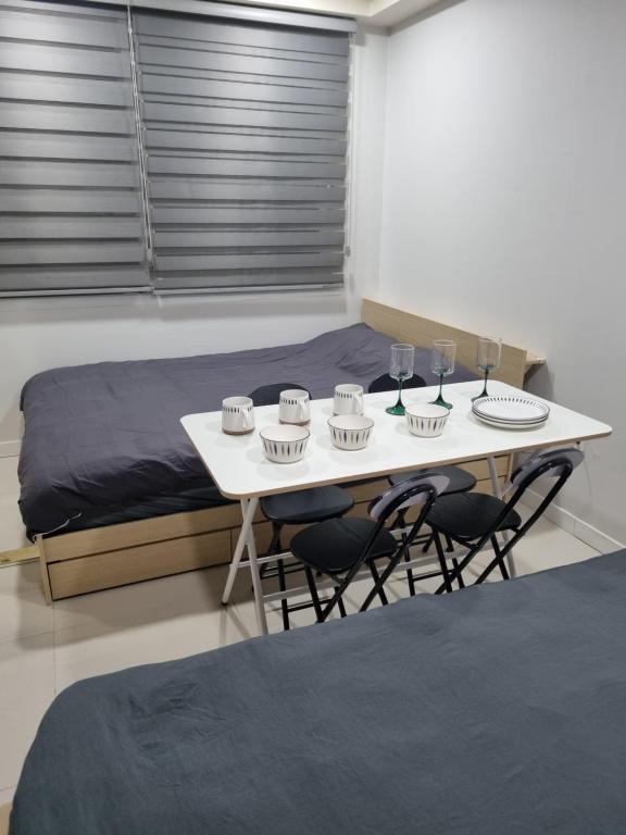 a table with chairs and glasses on it with a bed at ValueStay Hotel 9A in Seoul