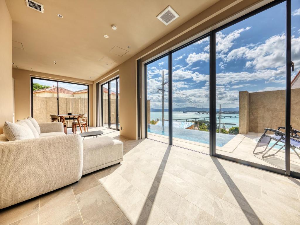 a living room with large windows and a couch at Kandor Resort Okinawa in Nakijin