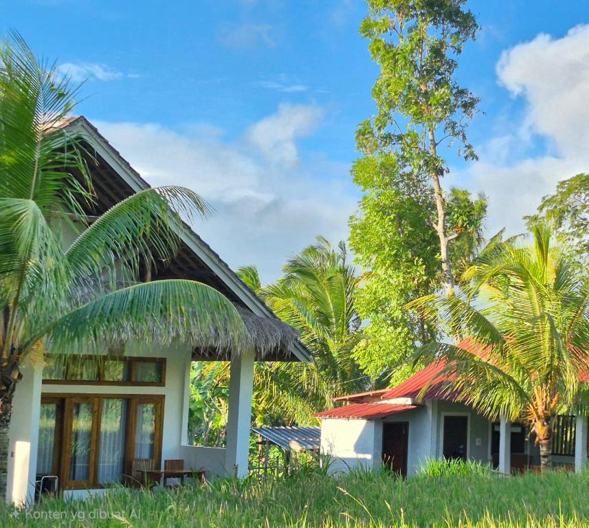a house with a red roof and some palm trees at Greenfield-Lombok in Tetebatu