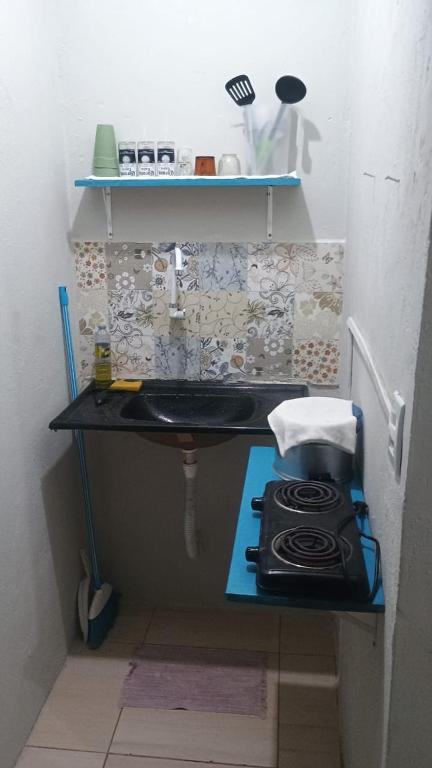 a small kitchen with a sink and a stove at Ap do Jhone in Canoa Quebrada